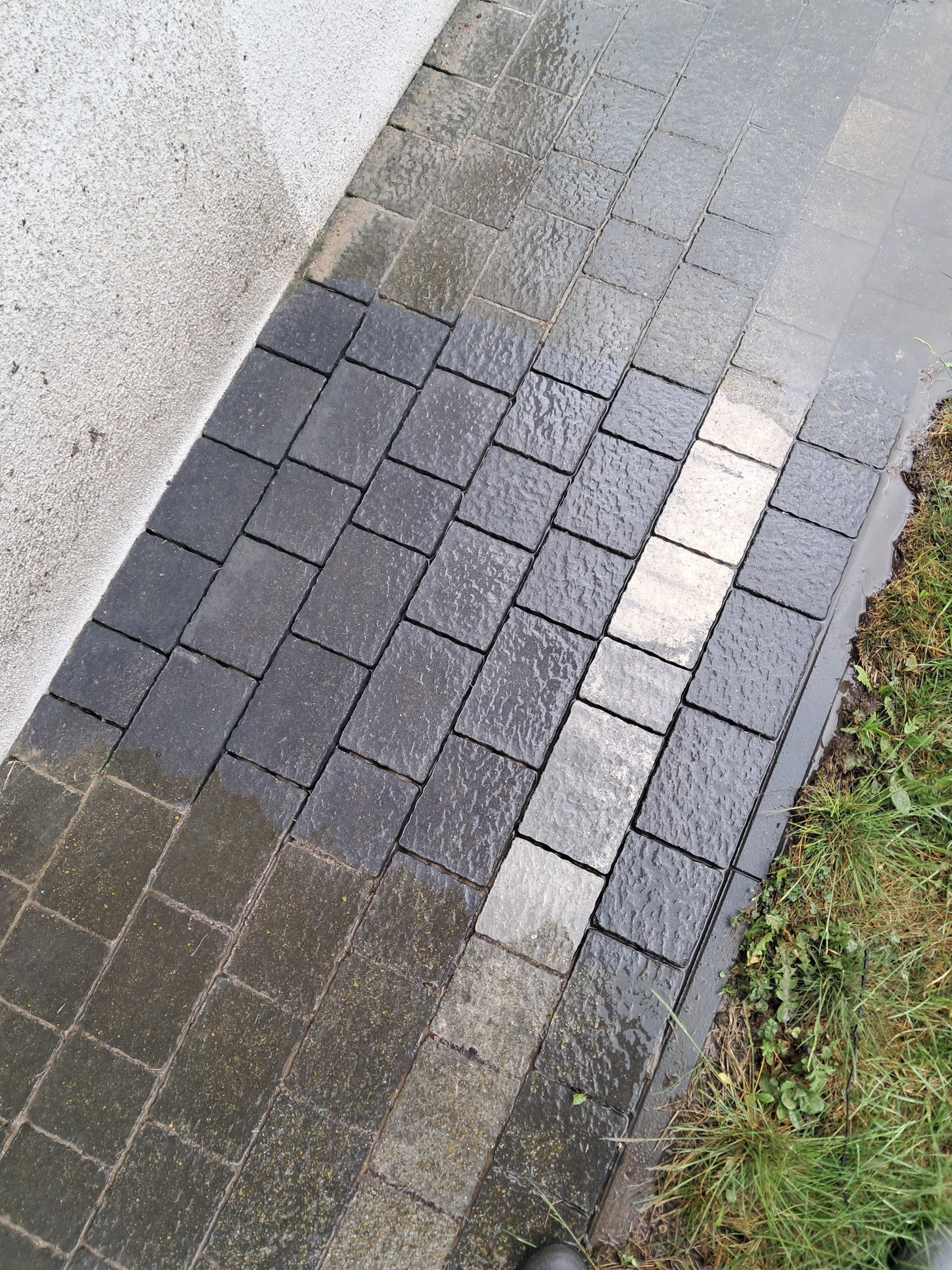 Doczyszczona kostka brukowa przy trawniku po myciu ciśnieniowym